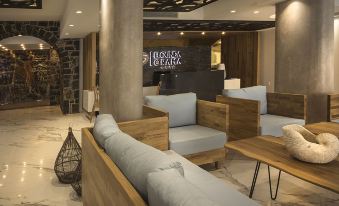 "a modern lounge area with wooden furniture and a sign that reads "" great sea "" on the wall" at Elounda Orama