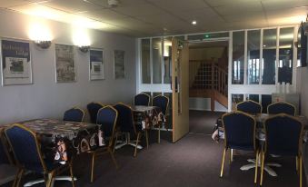 a dining room with several tables and chairs arranged for a group of people to enjoy a meal together at Redwings Lodge Rutland