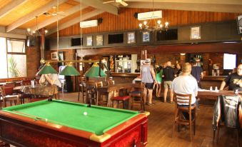 a group of people gathered in a room , playing pool and enjoying each other 's company at Bonnie Doon Hotel