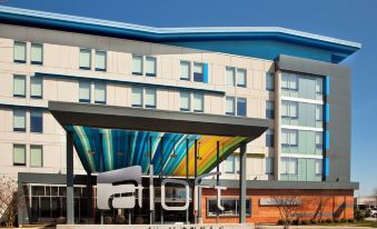 "a modern hotel building with an art installation and the name "" aloft "" written in black letters on the roof" at Aloft Chesapeake