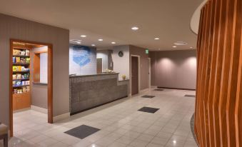 a hotel lobby with a reception desk and a staircase leading to the second floor at SpringHill Suites by Marriott Thatcher