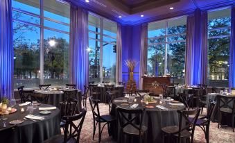 a well - lit dining room with tables and chairs arranged for a group of people to enjoy a meal at Raleigh Marriott City Center