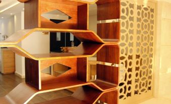 a modern bookshelf with multiple shelves and gold accents is displayed against a wall with a geometric pattern at Sofi Hotel