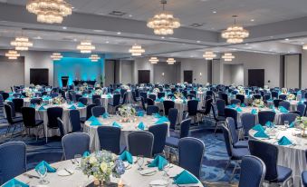 a large banquet hall filled with round tables and chairs , all set for a formal event at Crowne Plaza Boston - Woburn, an IHG Hotel