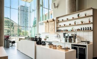 a modern coffee shop with a large window , allowing natural light to fill the space at Civic Hotel, Autograph Collection