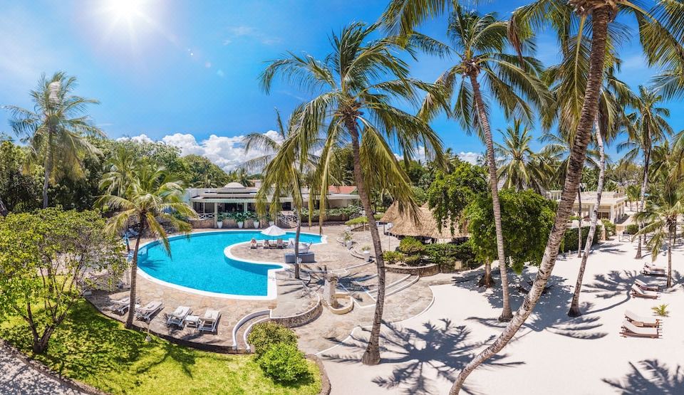 an aerial view of a resort with a large pool surrounded by palm trees and lounge chairs at Diamonds Dream of Africa