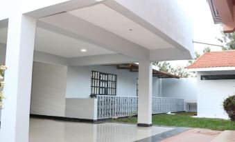 a white building with a metal railing and an open courtyard , allowing natural light to enter the space at The Orient Hotel