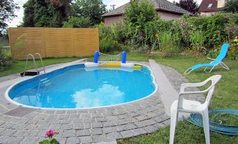 a backyard with a small swimming pool surrounded by a brick patio , and a hot tub nearby at Nepomuk