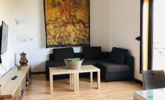a cozy living room with a black couch , wooden coffee table , and a large painting on the wall at Bellevue