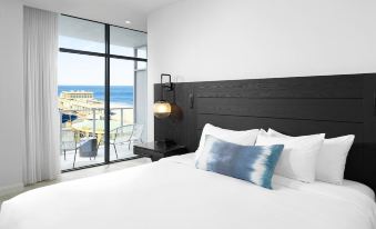 a bedroom with a large bed and a view of the ocean through a window at Wave Resort