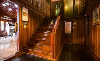 The stairs leading to the first floor are made of wood and feature glass panels at True Siam Phayathai Hotel