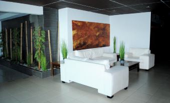 a modern living room with white furniture , including a couch and coffee table , and a large abstract painting on the wall at Hotel St. George