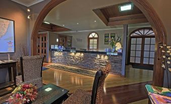 a restaurant with a wooden floor and chairs , tables , and a stone reception desk at Sleepy Hill Motor Inn