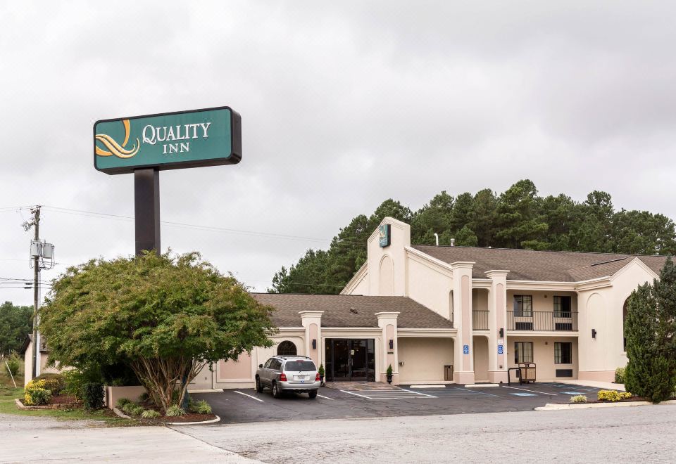 a large building with a quality inn sign on top and a parking lot in front at Quality Inn South Hill I-85