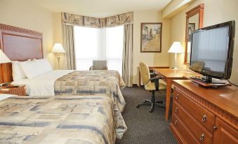 a hotel room with two beds , a desk , and a tv , all neatly arranged in the room at Quality Inn & Suites Bay Front