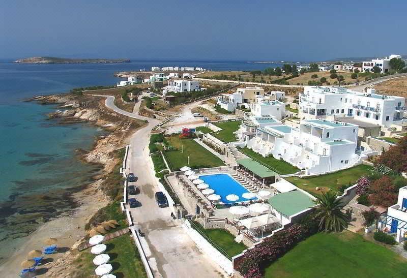 aerial view of a beach resort with a large pool surrounded by white buildings , villas , and grassy areas at Saint George Hotel