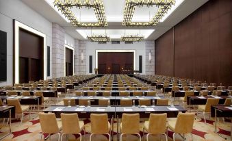 a large conference room with rows of chairs arranged in a semicircle , creating an auditorium - like setting at The Romanos, a Luxury Collection Resort, Costa Navarino