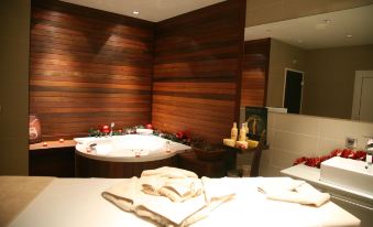 a spa room with a bathtub , candles , and towels , giving it a cozy and relaxing atmosphere at Festa Winter Palace Hotel