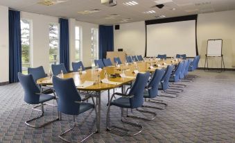 a conference room set up for a meeting , with several chairs arranged in a semicircle around a table at Langstone Quays Resort