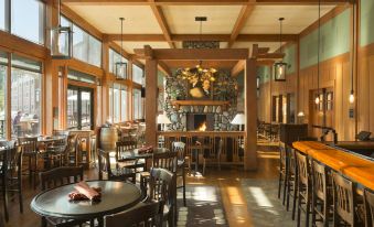 a spacious , well - lit restaurant with wooden beams and large windows , containing several dining tables and chairs at Skamania Lodge
