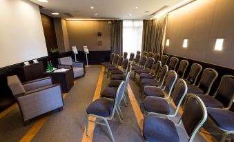 a conference room with rows of chairs arranged in a semicircle , ready for a meeting or presentation at Hotel Forum