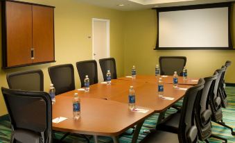 a conference room with a large table , multiple chairs , and several bottles of water on the table at SpringHill Suites Alexandria