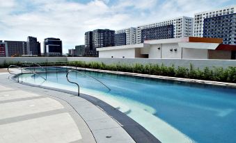 a large , empty swimming pool surrounded by a brick wall , with buildings in the background at Hotel 101 Manila