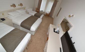 a hotel room with three beds , two of which are twin beds and one is a double bed at Bay View Hotel