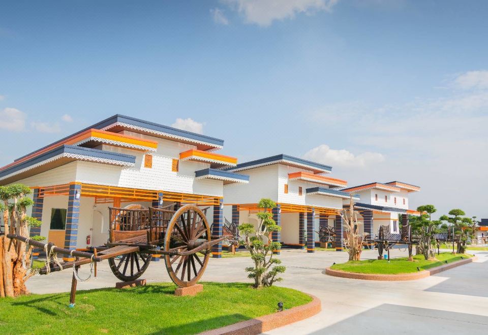 a modern house with an orange roof and white walls , situated on a grassy area with a wooden carriage at Infinity See Sun Resort