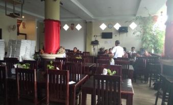 a dining room with wooden tables and chairs , where people are seated and enjoying their meals at Sacca Residence & Resto