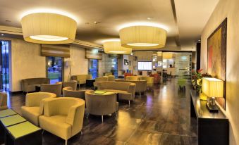 a well - lit lobby with multiple chairs and couches arranged for guests to relax and socialize at Hotel Cruise