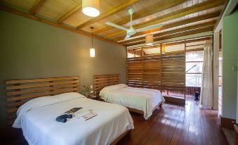 a room with two beds , one on the left side and the other on the right side of the room at Heliconia Amazon River Lodge