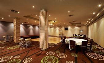 a large , empty room with multiple tables and chairs set up for a party or event at Nightcap at Waltzing Matilda Hotel