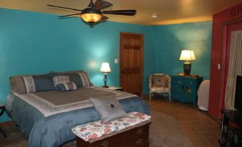 a cozy bedroom with blue walls , a large bed , and a tv mounted on the wall at Thyme for Bed