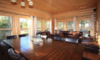 a spacious living room with wooden furniture , including a couch , chairs , and a dining table at Fiddler Lake Resort