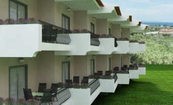 a row of balconies on a white building with greenery in the background , creating a serene outdoor setting at Asteris Village