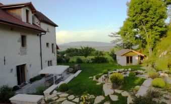 a beautiful backyard with a grassy lawn , a gazebo , and a view of the mountains in the distance at Le Manoir