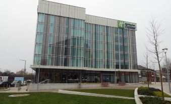 "a large , modern building with a green roof and the words "" holiday inn "" on it" at Holiday Inn Express Stockport