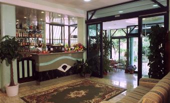 a modern hotel lobby with an elegant bar , large windows offering views of trees , and comfortable seating at Hotel Hamilton