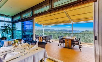 an outdoor dining area with several tables and chairs arranged for a group of people to enjoy a meal at Hotel Panorama