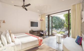 a modern bedroom with a large window and sliding glass door , featuring white walls and furniture at W Goa