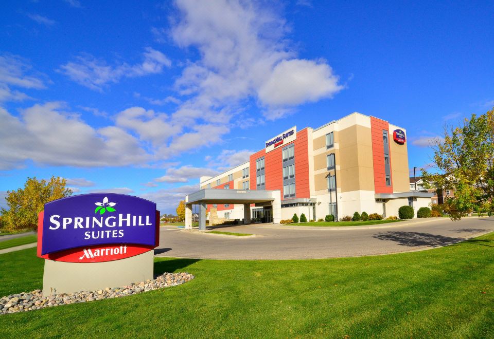 "a large building with the name "" springhill suites by marriott "" in large letters , standing outside under a blue sky" at SpringHill Suites Grand Forks