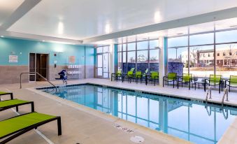 a large indoor swimming pool with a blue and white striped lounge chair in the background at SpringHill Suites Columbia