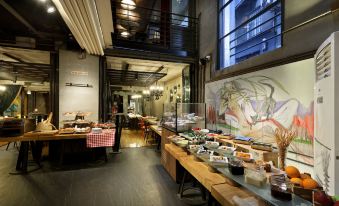 a dining room with a long buffet table filled with various food items , including sandwiches , salads , and other dishes at Hotel the Public - Special Category