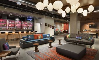 a modern lounge area with various seating options , including couches , chairs , and a coffee table at Aloft Hillsboro-Beaverton