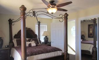 a bed with a metal frame and canopy is shown in a bedroom with a ceiling fan at Kings Point