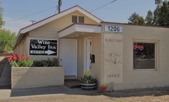 "a small building with a sign that says "" wine valley inn "" and a potted plant in front" at Wine Valley Inn