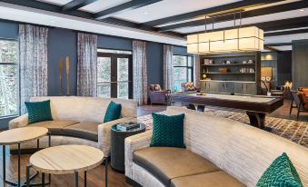 a modern living room with blue walls , wooden floors , and various seating arrangements including couches , chairs , and a dining table at Grand Hyatt Vail