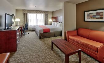 a hotel room with a king - sized bed , a couch , a television , and a bathroom at Holiday Inn Roswell