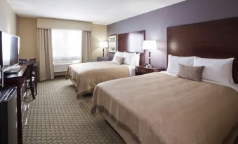 a hotel room with two beds , one on the left side and the other on the right side of the room at Grandstay Hotel Suites Thief River Falls